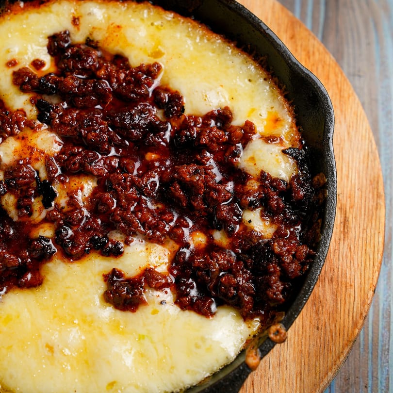 Hecho en Mexico's Queso Fundido, a cast iron skillet filled with melted cheese and chorizo.